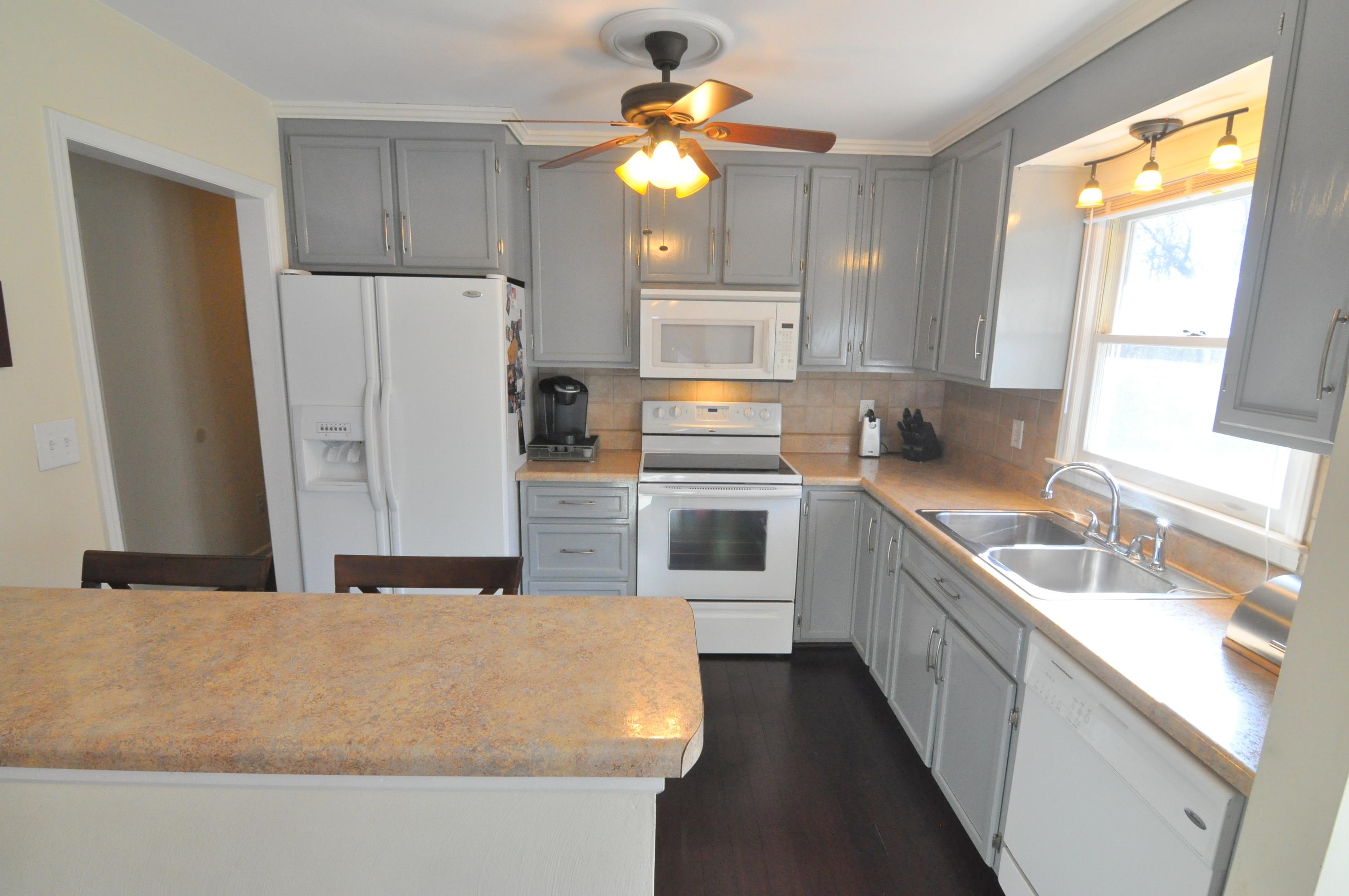 337 Fields Avenue Blue Ridge, VA 24064 - Photo 3 of 23 a kitchen with stainless steel appliances granite countertop a sink a stove a refrigerator a window with white cabinets and wooden floor