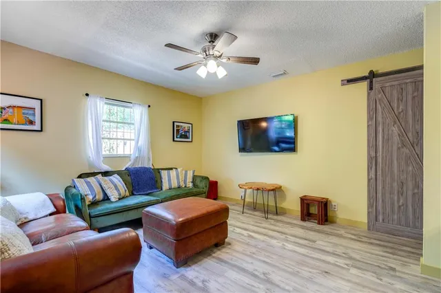 a kitchen with stainless steel appliances granite countertop a refrigerator a sink dishwasher a stove and white countertops with wooden floor