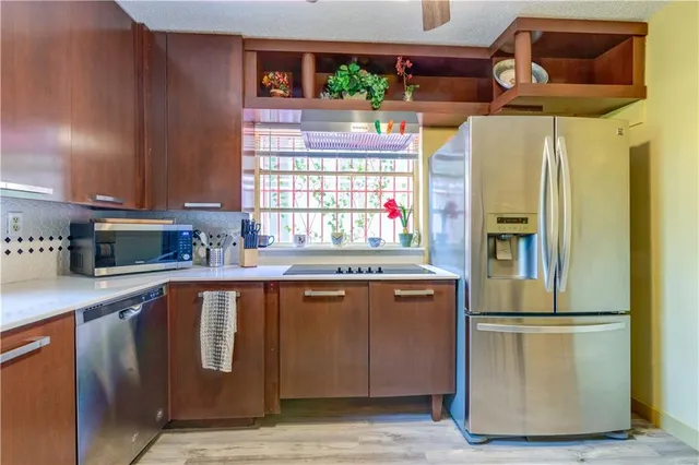 a kitchen with a refrigerator a sink and dishwasher with wooden floor