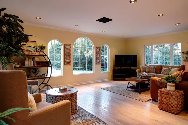 a living room with furniture a flat screen tv and a large window