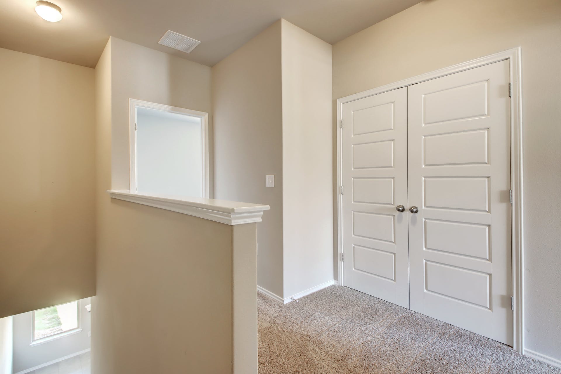 1202 Garland Road Georgetown, TX 78626 - Photo 18 of 28 Modern panel doors, neutral carpeting, and a half-wall with white trim