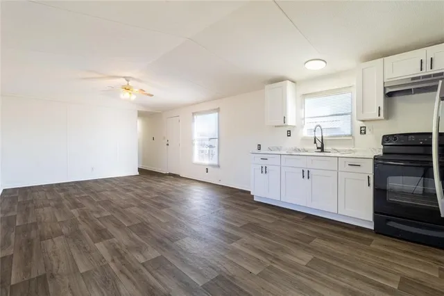 a kitchen with a sink a stove and cabinets