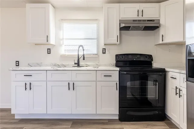 a kitchen with granite countertop a stove and a sink