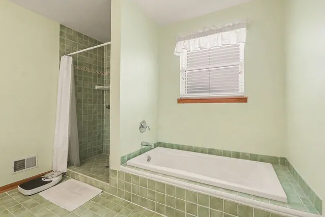 a bathroom with a tub and a shower