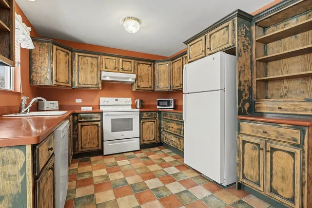 a kitchen with a refrigerator sink and cabinets