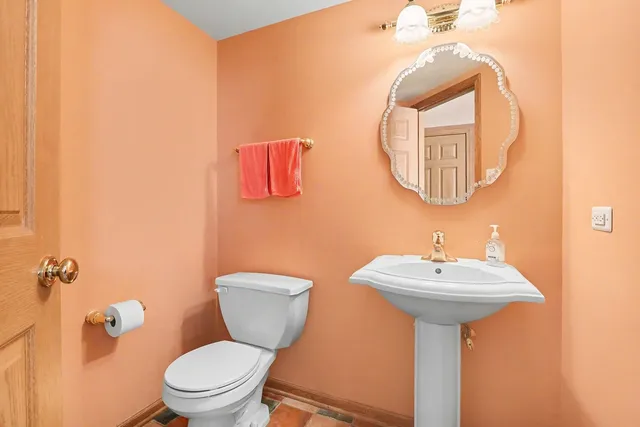 a bathroom with a toilet sink and mirror