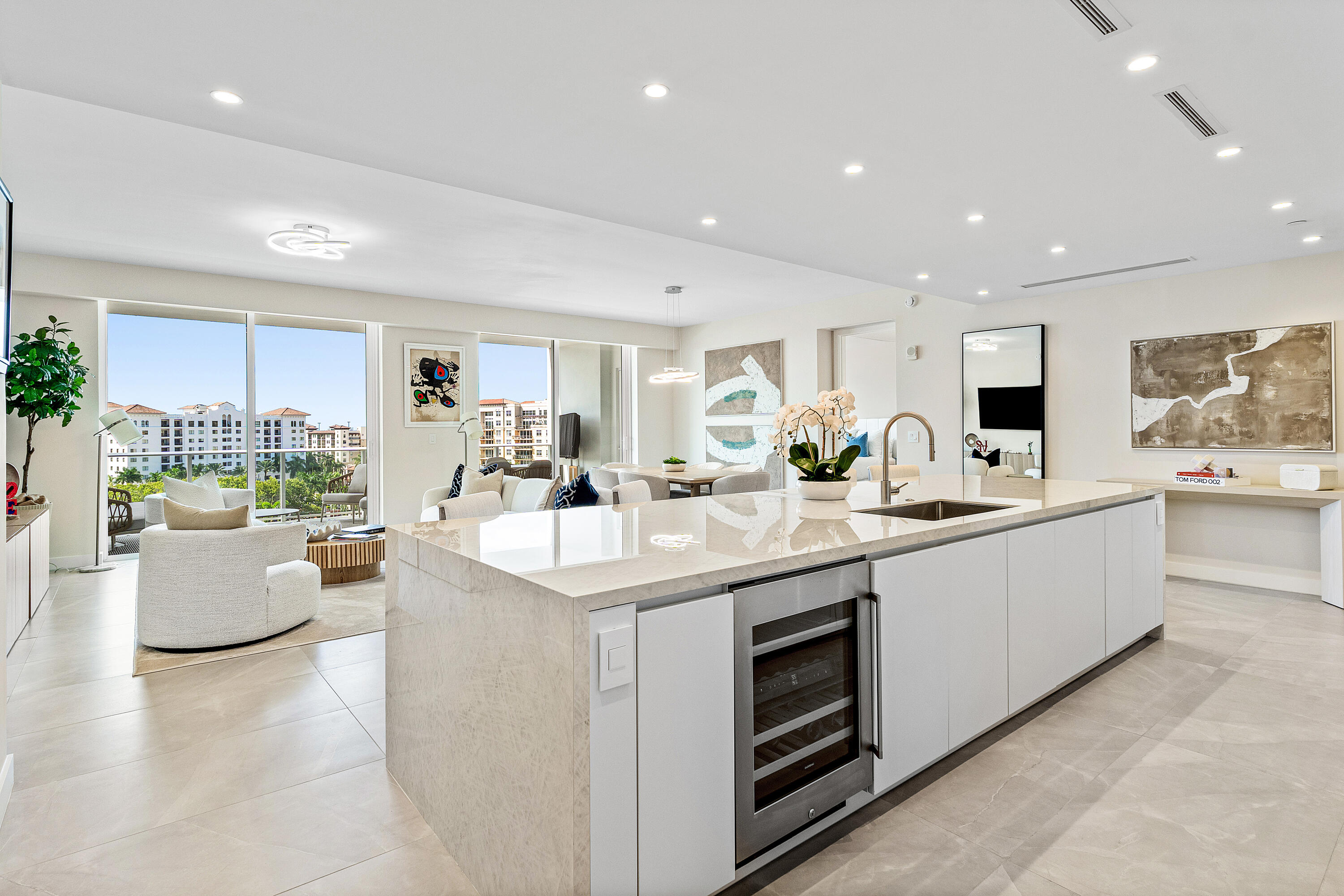 a large white kitchen with a large window and white stainless steel appliances