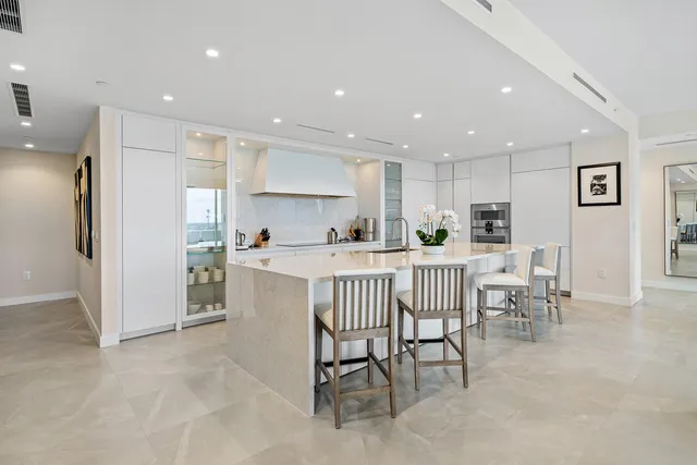 a kitchen with a dining table chairs refrigerator and cabinets