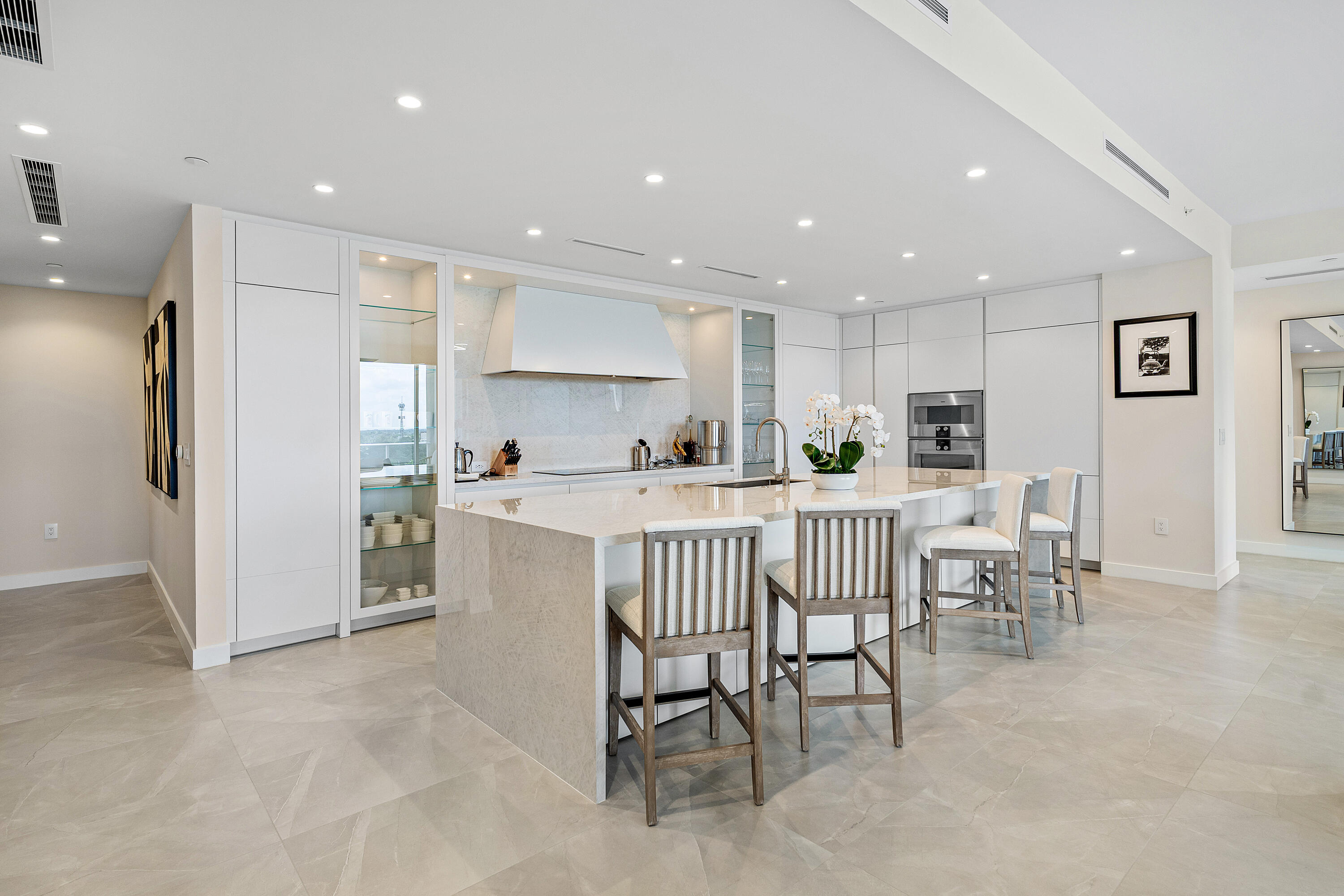 220 Southeast Mizner Boulevard, Unit 810 Boca Raton, FL 33432 - Photo 15 of 39 a kitchen with a dining table chairs refrigerator and cabinets