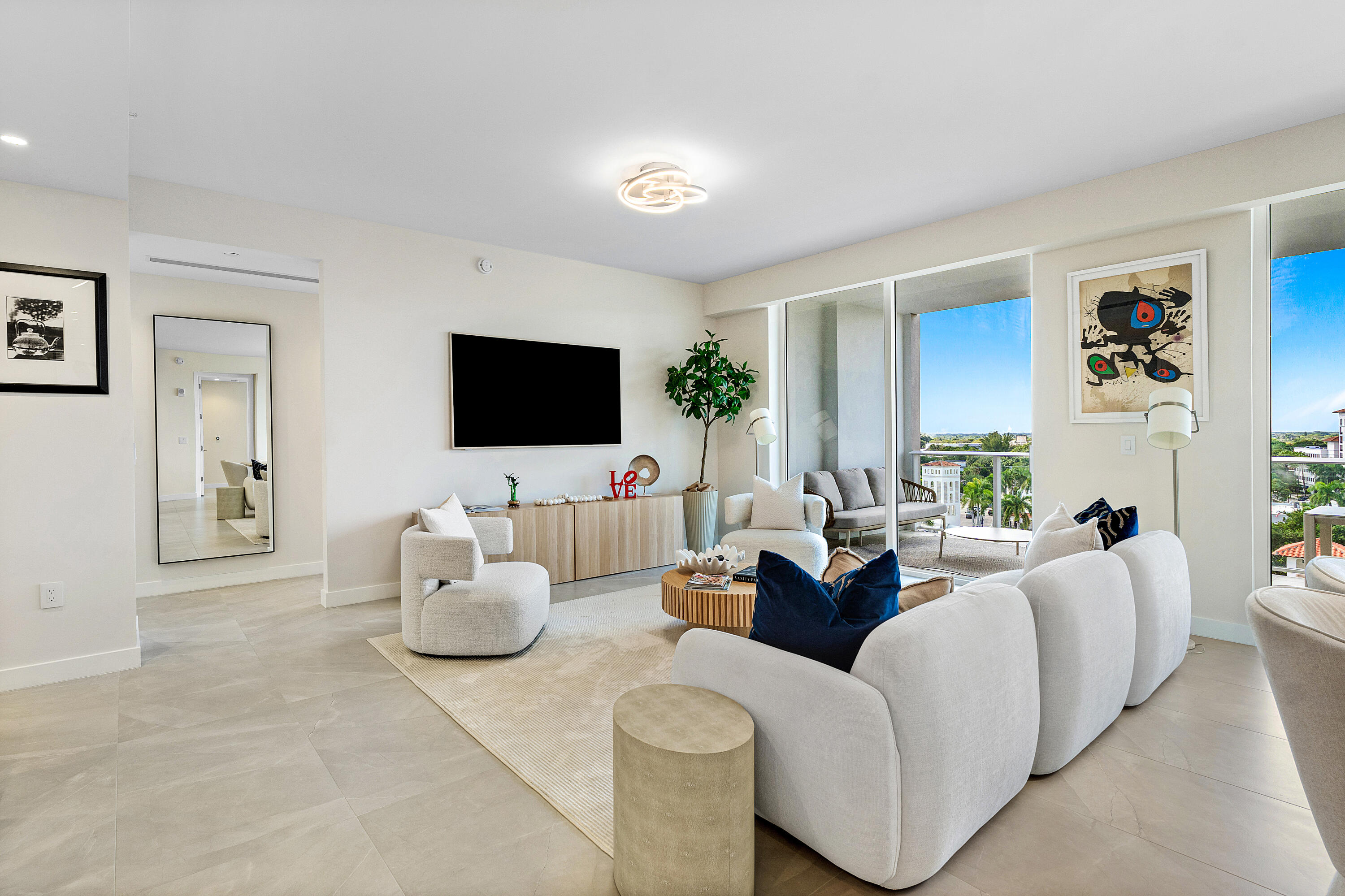 220 Southeast Mizner Boulevard, Unit 810 Boca Raton, FL 33432 - Photo 3 of 39 a living room with furniture and a flat screen tv