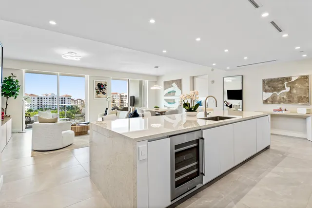 a large white kitchen with a large window and white stainless steel appliances