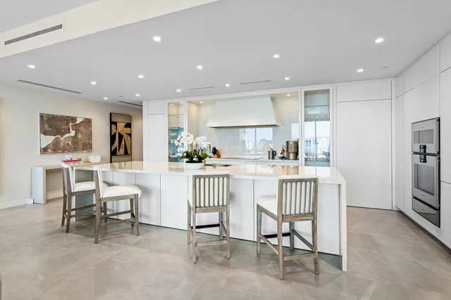 a kitchen with stainless steel appliances kitchen island granite countertop a refrigerator and cabinets
