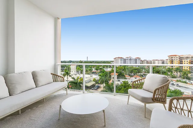 a living room with furniture a table and a floor to ceiling window