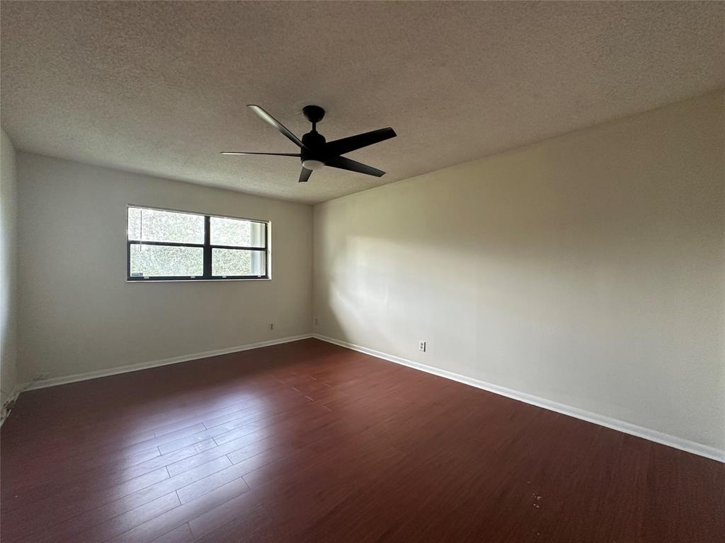 22415 Southwest 61st Way, Unit 202 Boca Raton, FL 33428 - Photo 3 of 14 a view of a big room with wooden floor and windows