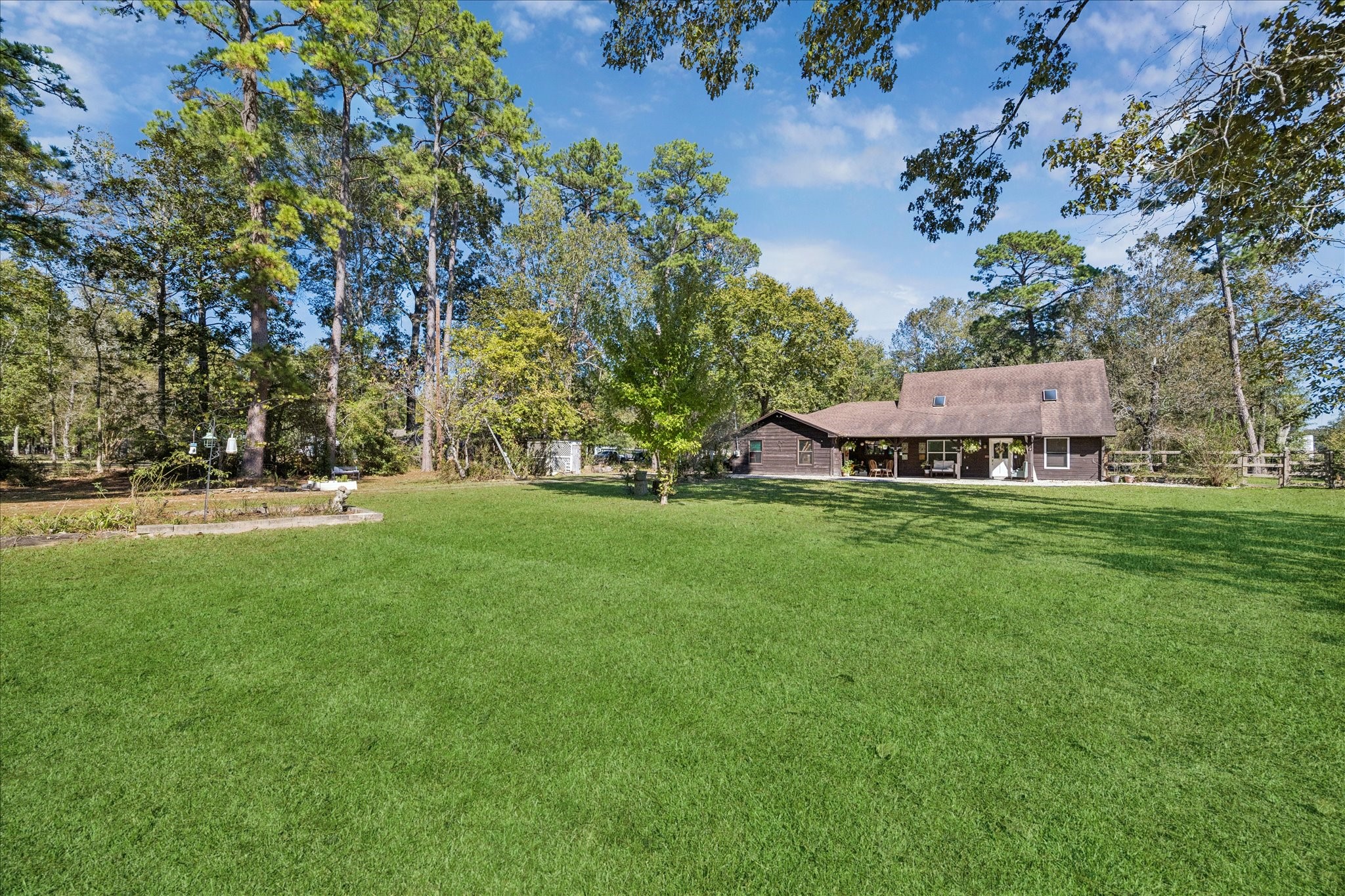 6 B Davidson Lane Huffman, TX 77336 - Photo 1 of 20 Charming rustic home surrounded by lush greenery gardens, and tall trees, featuring a spacious lawn and a cozy, inviting exterior. Ideal for those seeking tranquility and nature.