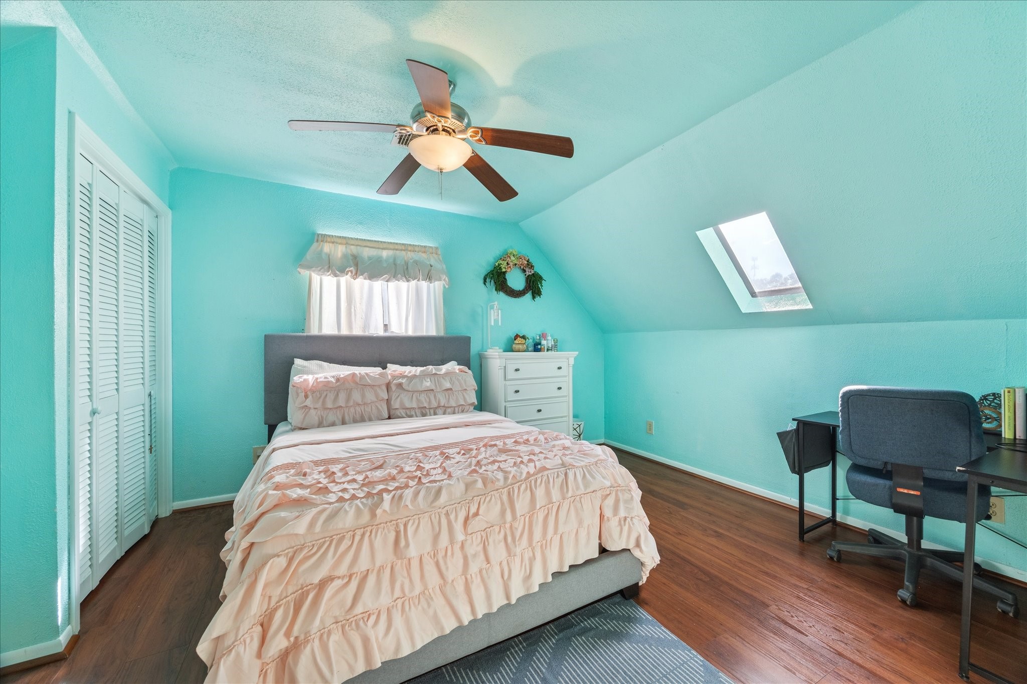 6 B Davidson Lane Huffman, TX 77336 - Photo 14 of 20 This bedroom features teal walls, a ceiling fan, and a skylight that brightens the space. It has hardwood floors. It is such a charming and functional room.