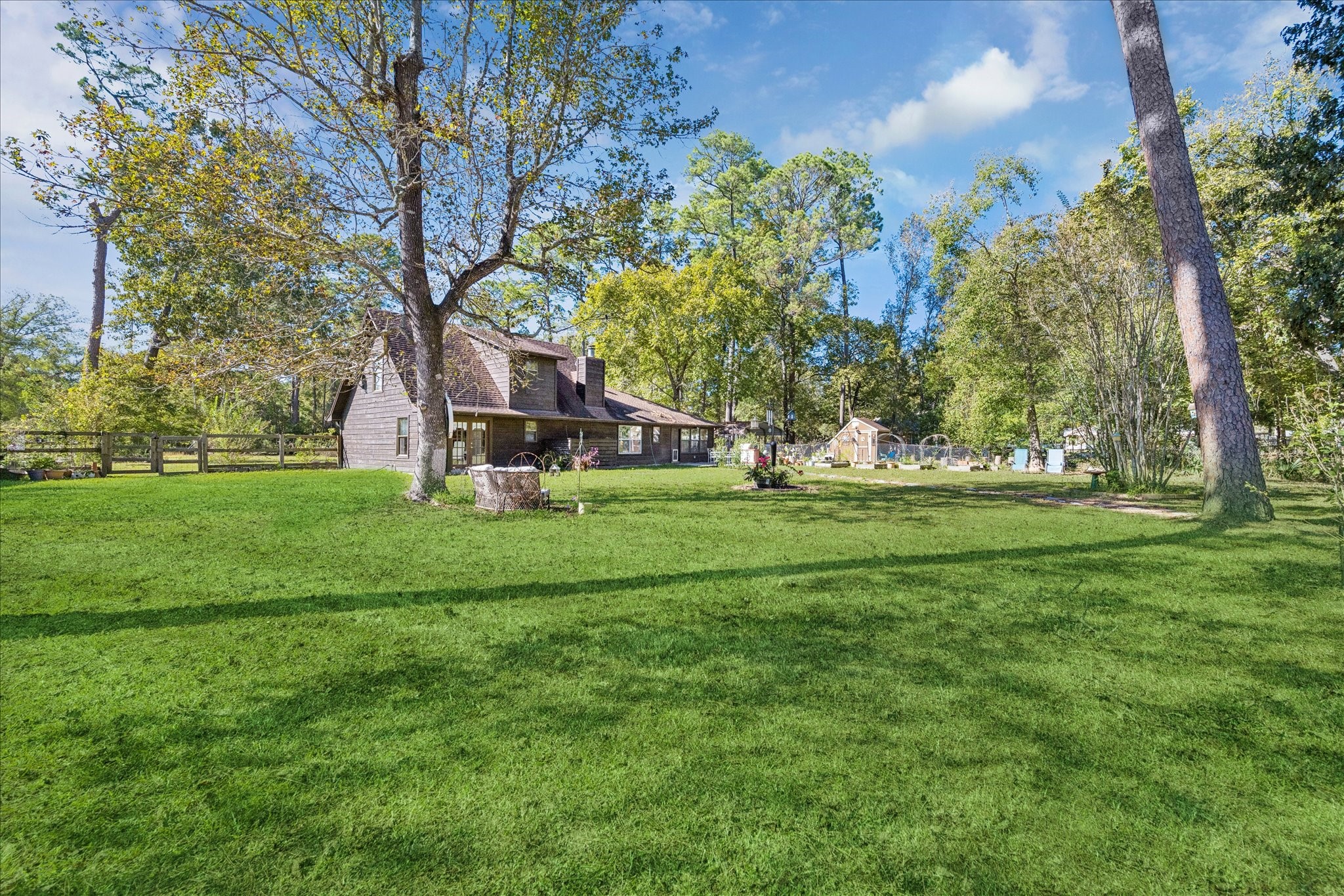 6 B Davidson Lane Huffman, TX 77336 - Photo 2 of 20 Charming rustic home set on a spacious, lush green lot surrounded by mature trees. The property features a fenced yard, providing privacy and a serene natural setting. Ideal for those seeking a peaceful retreat.