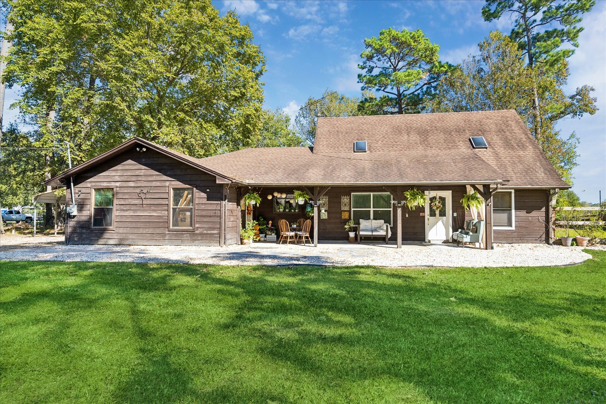 6 B Davidson Lane Huffman, TX 77336 - Photo 3 of 20 This charming home features a rustic exterior with a spacious porch, surrounded by lush greenery and mature trees. The property boasts a well-maintained lawn, perfect for outdoor activities. Ample windows provide plenty of natural light, creating a warm and inviting atmosphere.