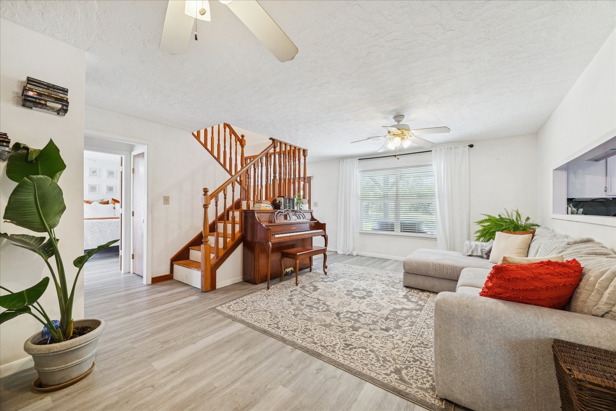 6 B Davidson Lane Huffman, TX 77336 - Photo 6 of 20 Bright and inviting living room with laminate easy to clean after a gathering. Imagine the family gathering together to socialize. A wooden staircase adds charm.