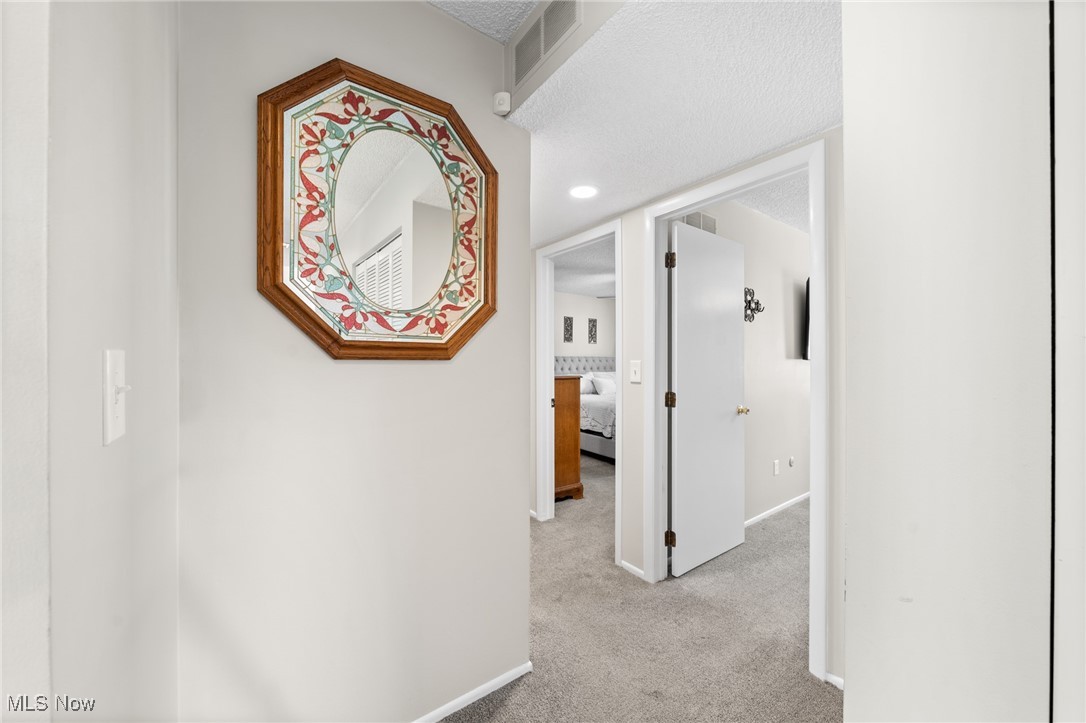 889 Hampton Ridge Drive Akron, OH 44313 - Photo 26 of 38 Corridor with light carpet and a textured ceiling