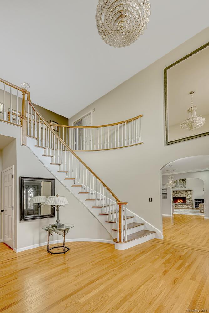 22 Golden Road Suffern, NY 10901 - Photo 11 of 41 Stairway with a high ceiling, wood finished floors, arched walkways, and a warm lit fireplace