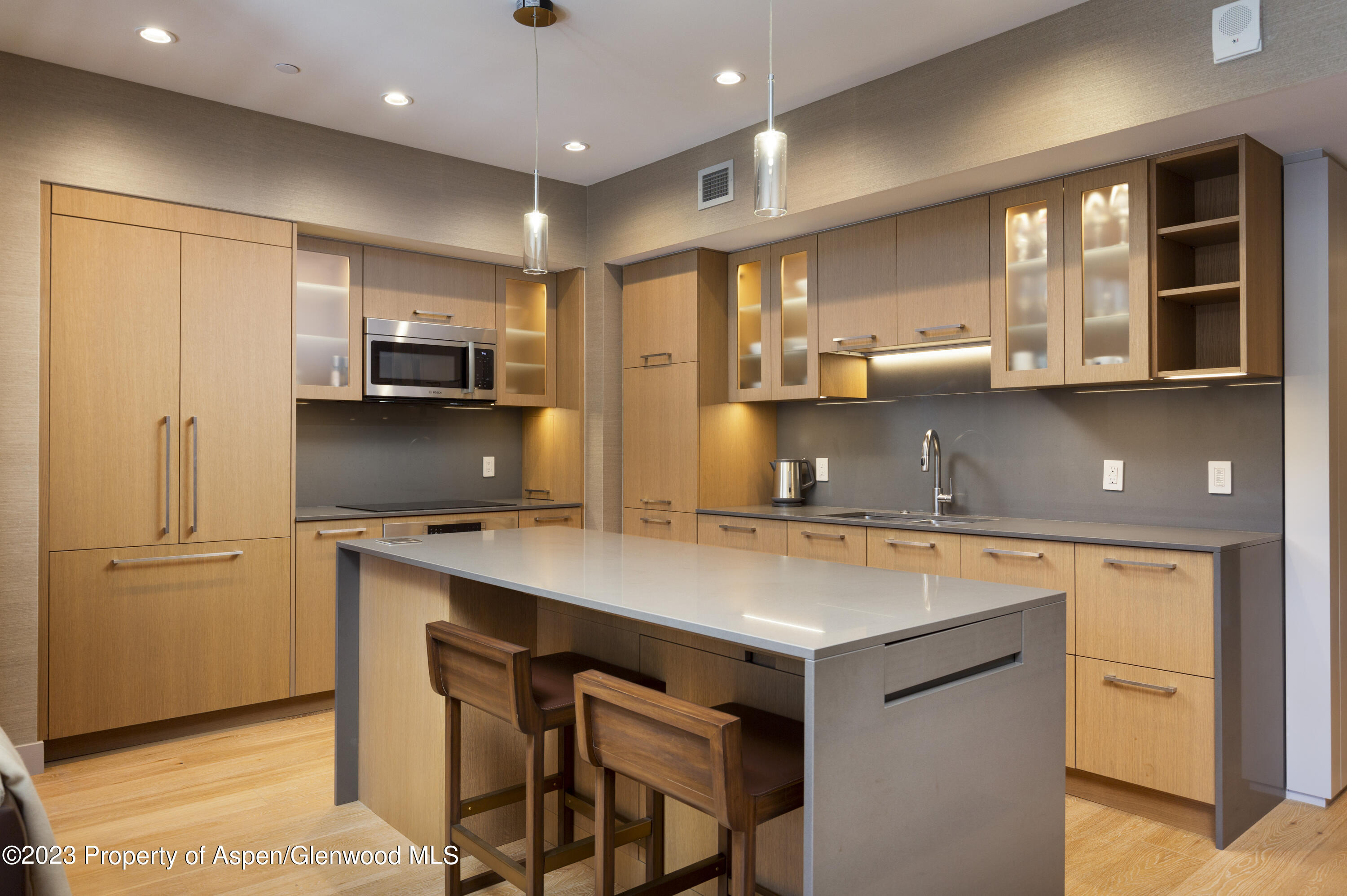 a kitchen with kitchen island a counter space a sink a refrigerator and a stove