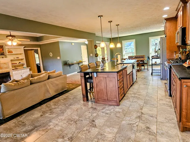 a living room with furniture a chandelier and a dining table