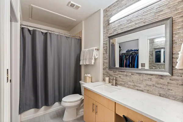 a bathroom with a granite countertop sink toilet and a mirror