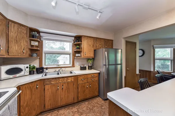 a kitchen with a sink a refrigerator and cabinets