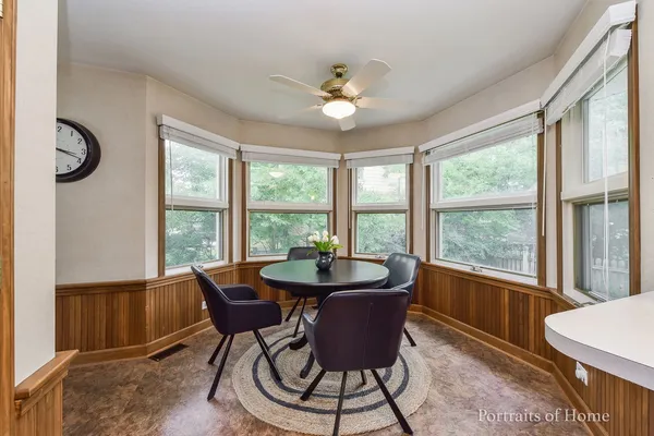 a dining room with furniture a chandelier and wooden floor