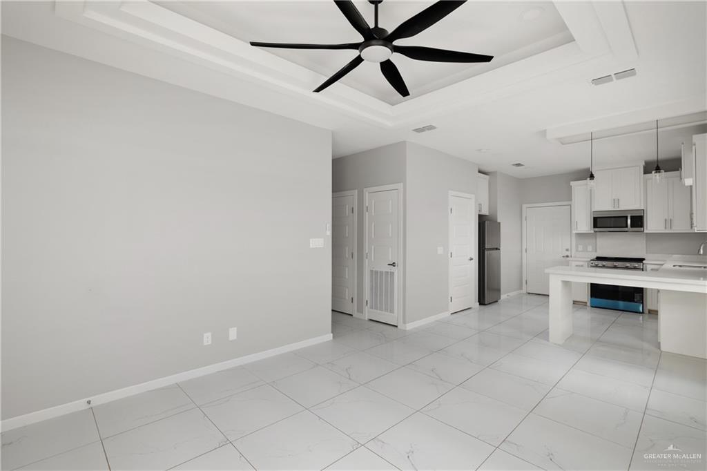 904 Deluxe Street Alamo, TX 78516 - Photo 3 of 11 Unfurnished living room featuring a tray ceiling and ceiling fan
