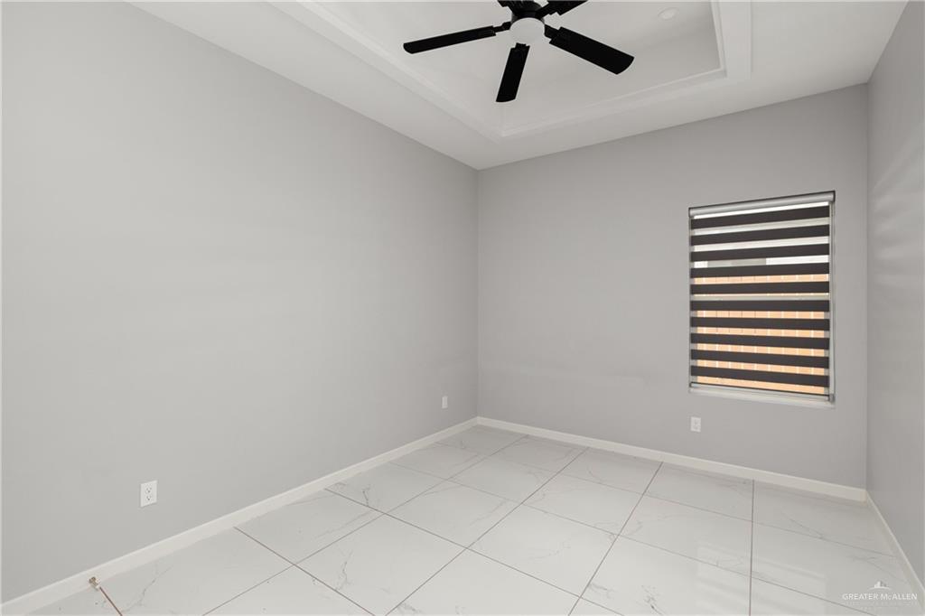 904 Deluxe Street Alamo, TX 78516 - Photo 6 of 11 Spare room with a tray ceiling and ceiling fan
