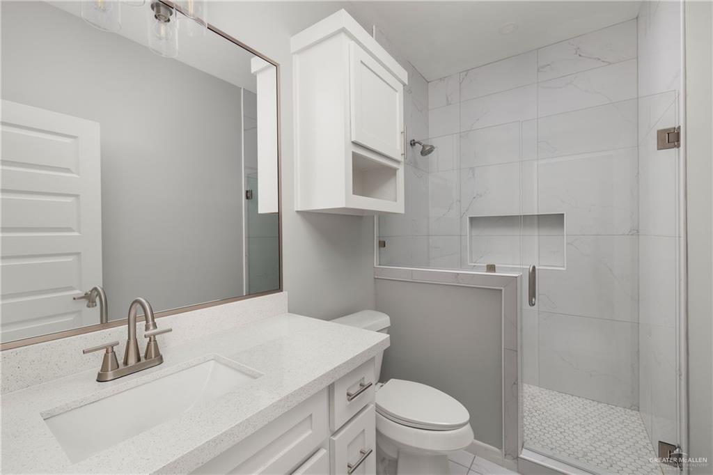 904 Deluxe Street Alamo, TX 78516 - Photo 9 of 11 Bathroom featuring a marble finish shower, vanity, and light tile patterned floors