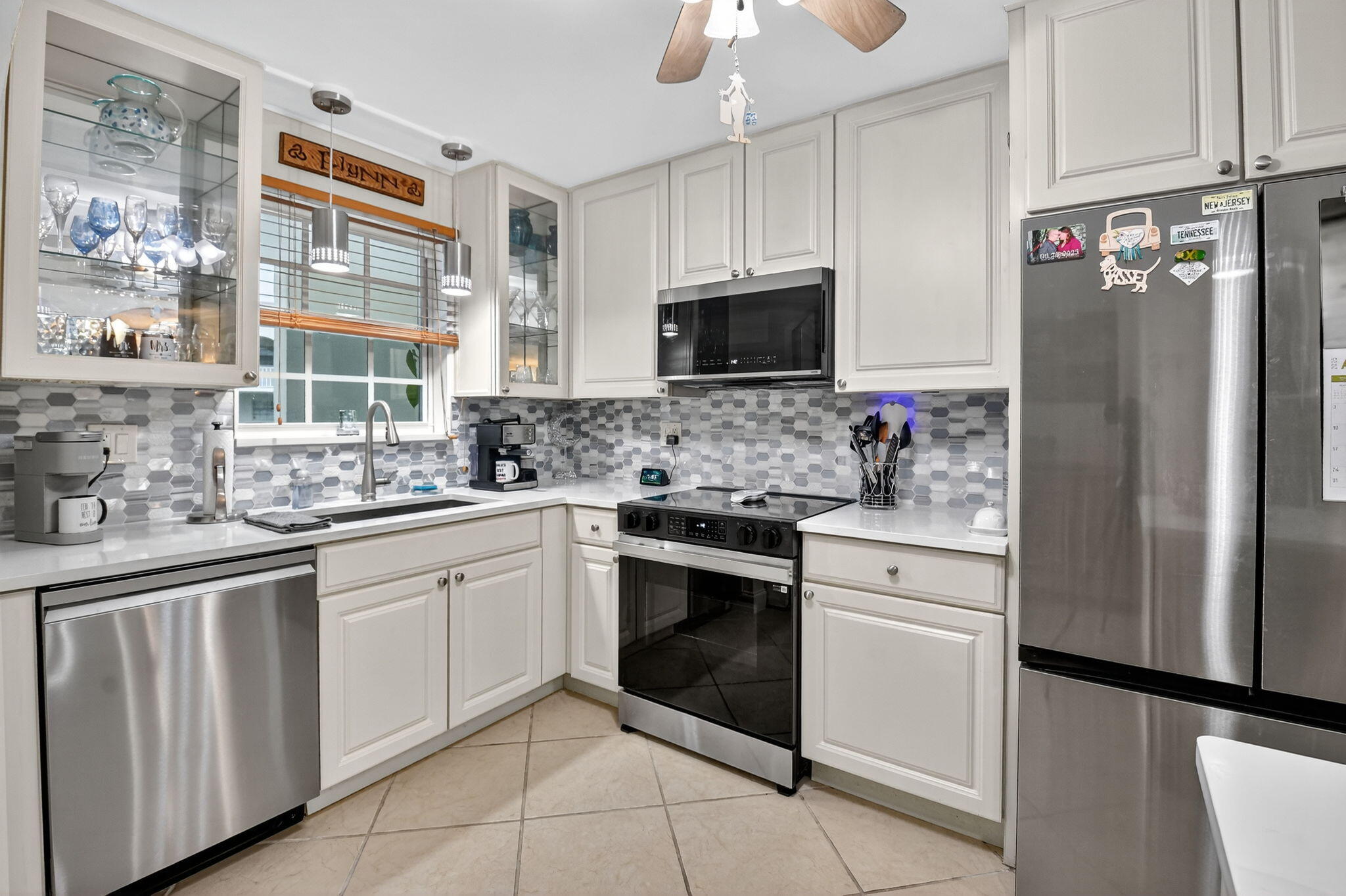 a kitchen with white cabinets stainless steel appliances and a sink