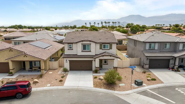 an aerial view of a house with a garden and car parked
