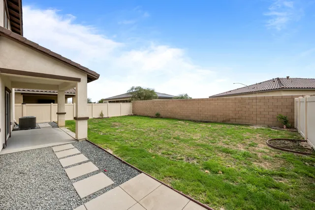 a view of a backyard with table and chairs and wooden fence