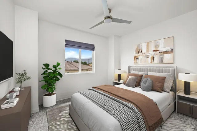 a bedroom with bed and a potted plant