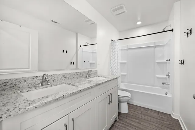 a bathroom with a granite countertop sink a toilet and shower
