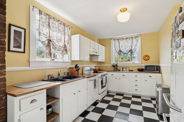 a kitchen with a sink a stove a cabinets and a window