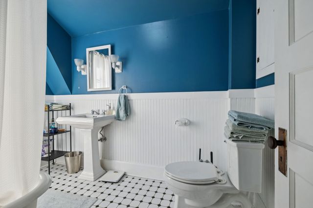 a bathroom with a sink a toilet and a mirror