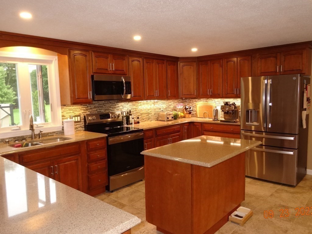 41 Hazen Road Shirley, MA 01464 - Photo 5 of 40 a kitchen with stainless steel appliances granite countertop a stove a sink and a refrigerator with wooden cabinets