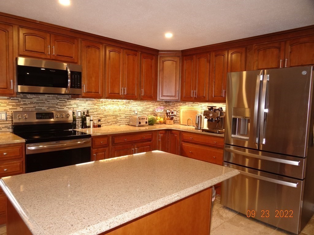 41 Hazen Road Shirley, MA 01464 - Photo 8 of 40 a kitchen with stainless steel appliances a refrigerator a stove a sink dishwasher and wooden cabinets with a large window