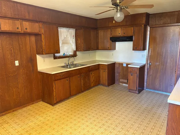 a kitchen with stainless steel appliances a sink cabinets and wooden floor