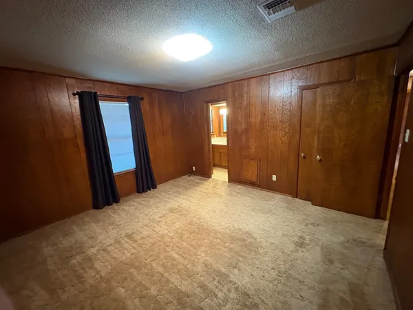 an empty room with closet and wooden floor