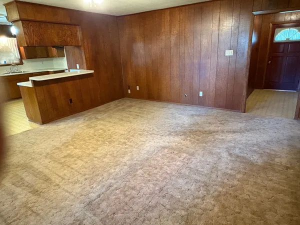 a view of a livingroom with an empty space and a window