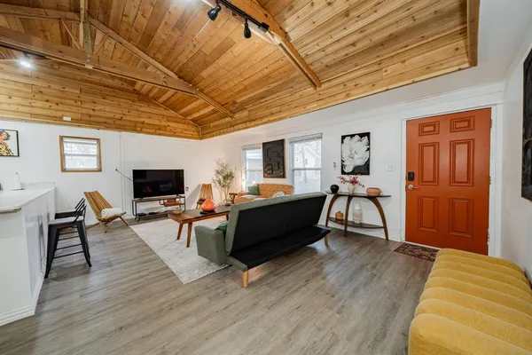 a living room with furniture a flat screen tv and kitchen view