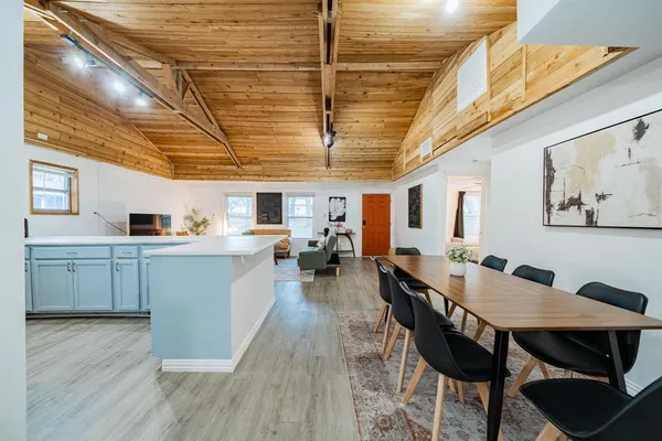 a kitchen with a dining table chairs and wooden floor