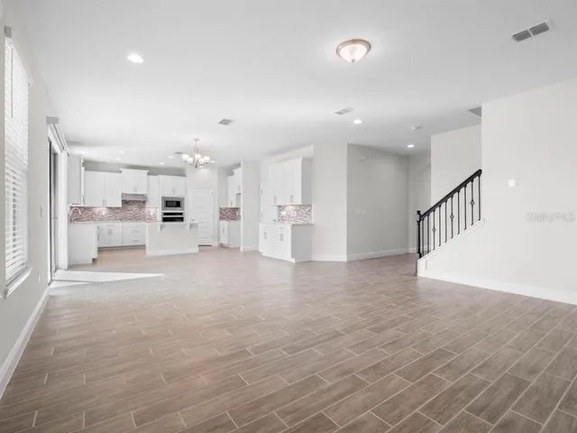 a large white kitchen with kitchen island a stove a refrigerator a sink dishwasher with a dining table and chairs