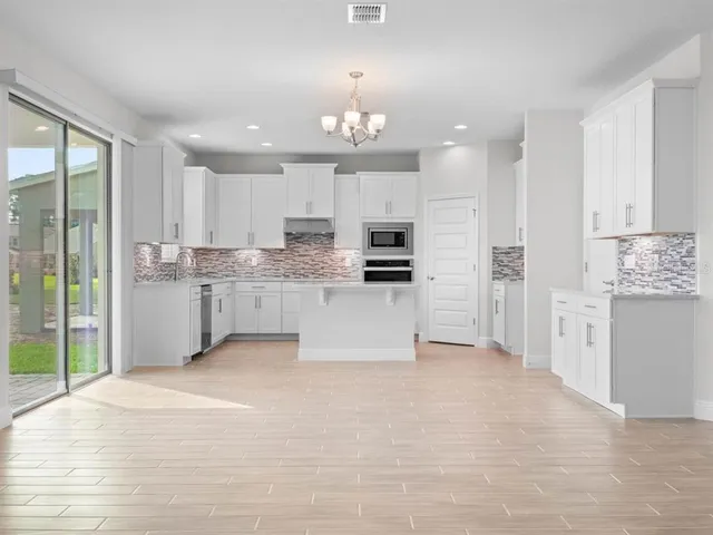 a large white kitchen with a sink and cabinets