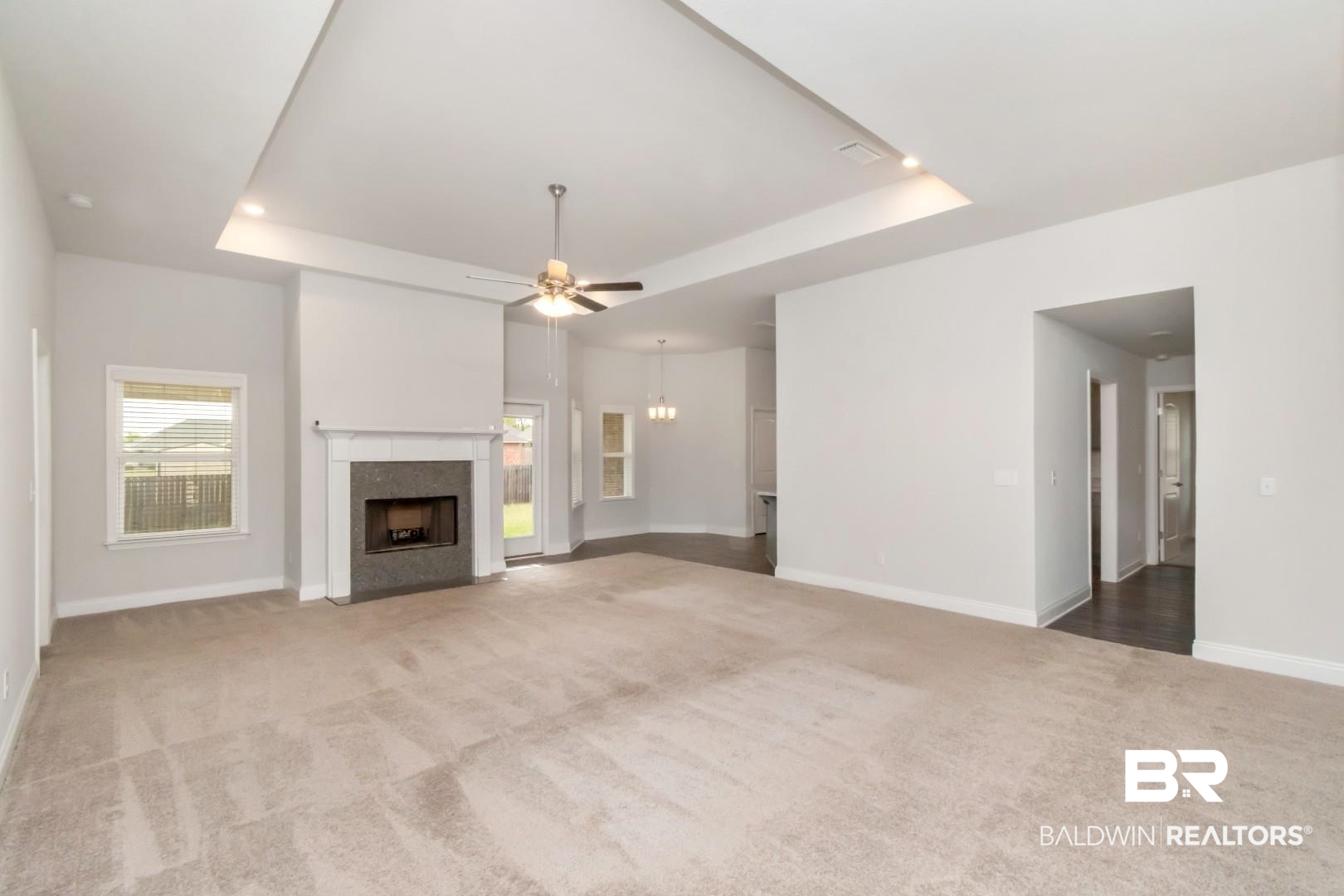 6632 Monarch Circle Mobile, AL 36618 - Photo 4 of 32 Unfurnished living room with a raised ceiling, carpet flooring, ceiling fan, and a fireplace